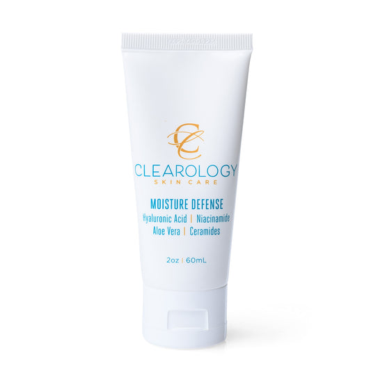A close-up of the tube of Clearology Skin Care Moisture Defense. The label lists ingredients like Hyaluronic Acid, Niacinamide, Aloe Vera, and Ceramides, and mentions it is sulfate-free, paraben-free, and fragrance-free.