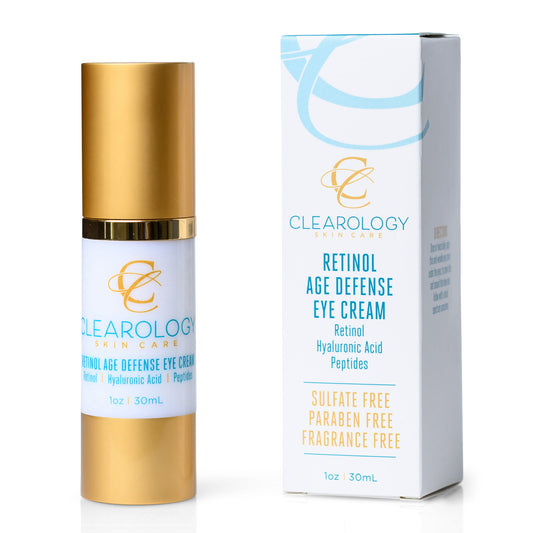 A bottle of Clearology Skin Care Retinol Age Defense Eye Cream with a gold lid and its matching white and blue packaging box. The label mentions ingredients such as Retinol, Hyaluronic Acid, and Peptides, and highlights that it is sulfate-free, paraben-free, and fragrance-free.